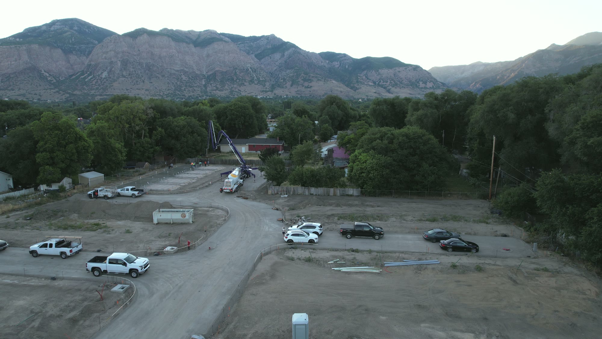 A concrete pump truck pouring footings at dawn on the Chester Street site in Ogden, with Ben Lomond behind