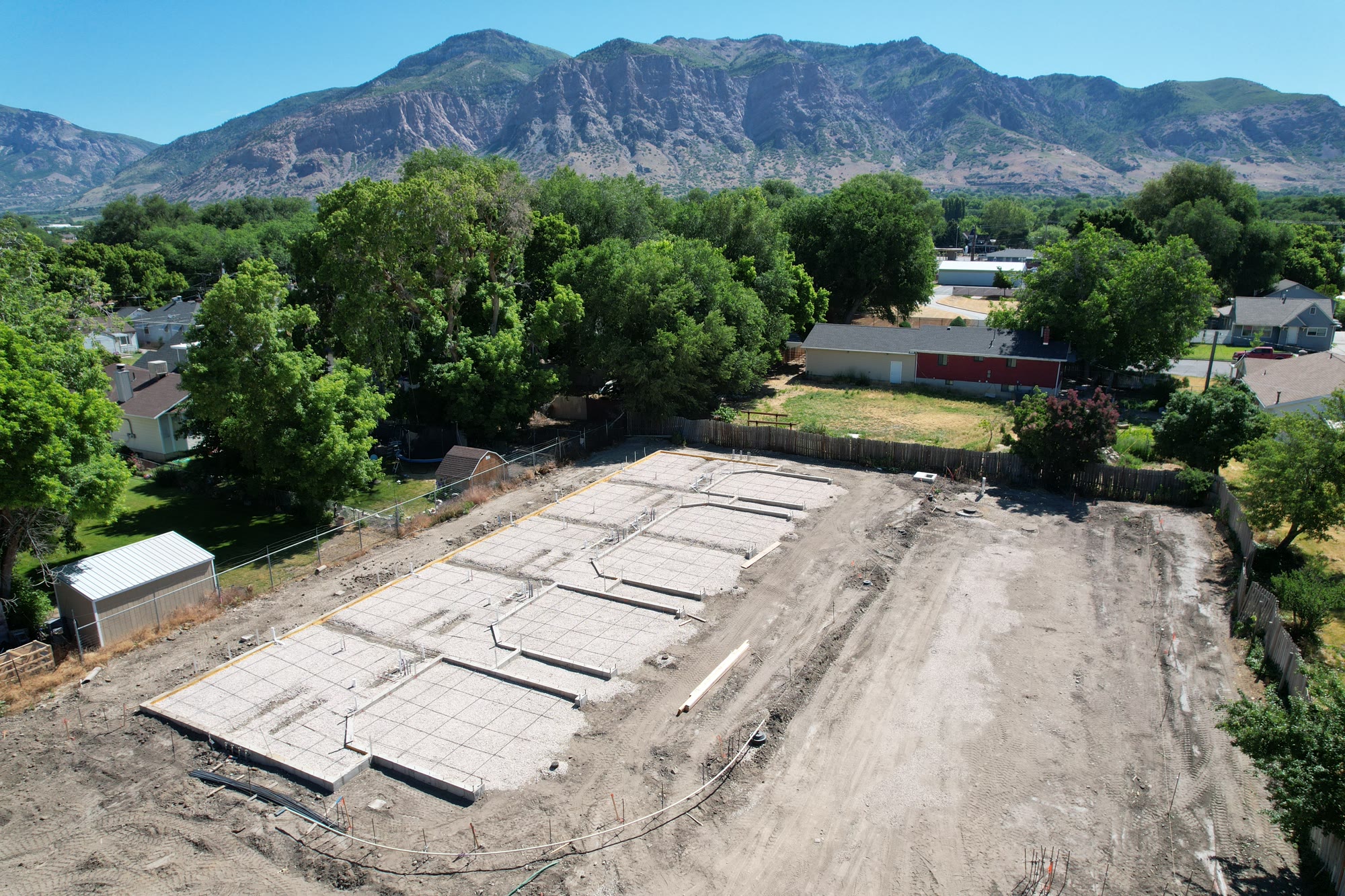 The Chester Street site in Ogden with footings poured, mountains rising behind