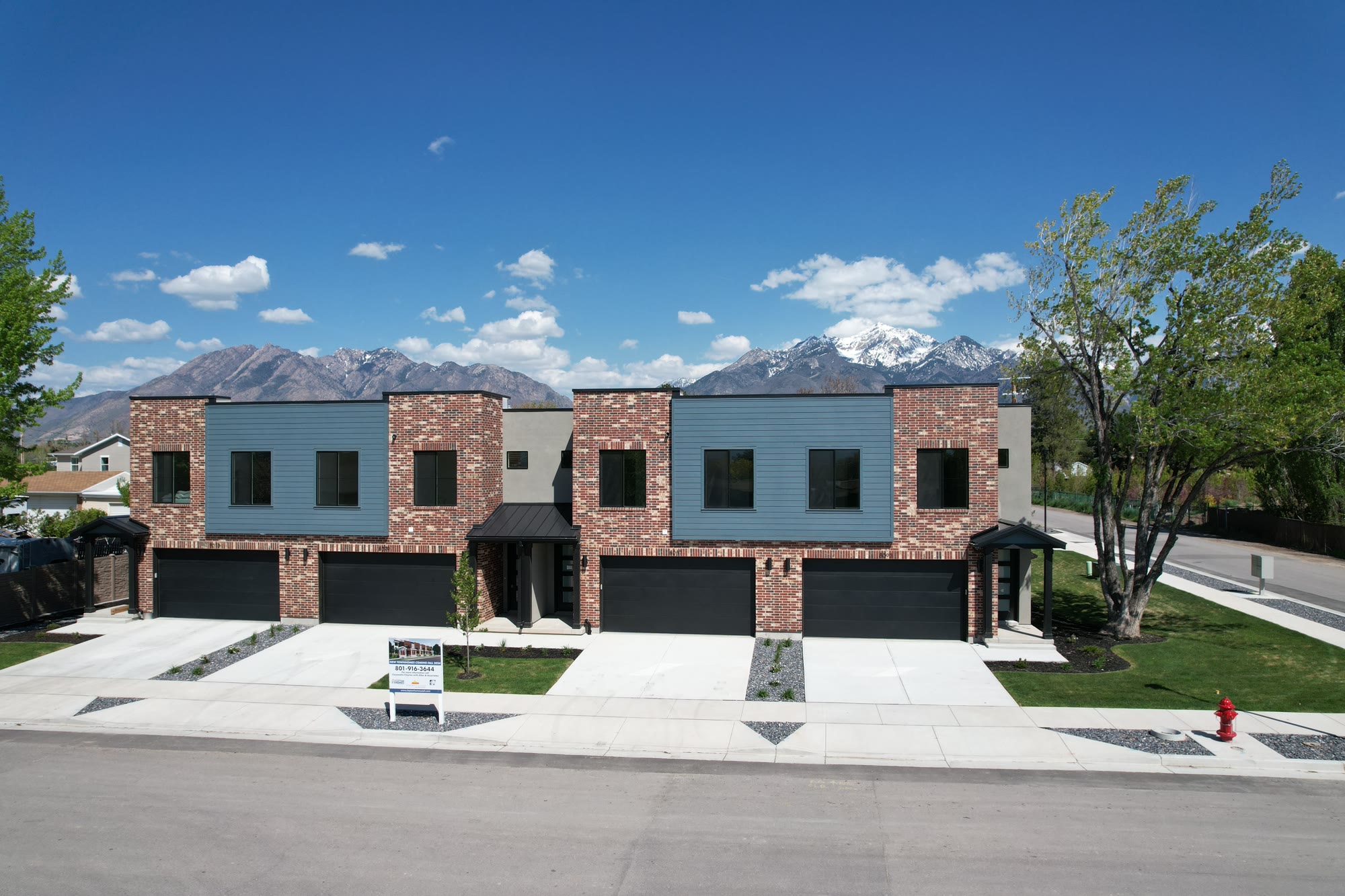 The landscaped, finished townhomes under a blue sky